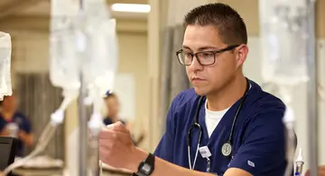 A nurse looks at an IV bag