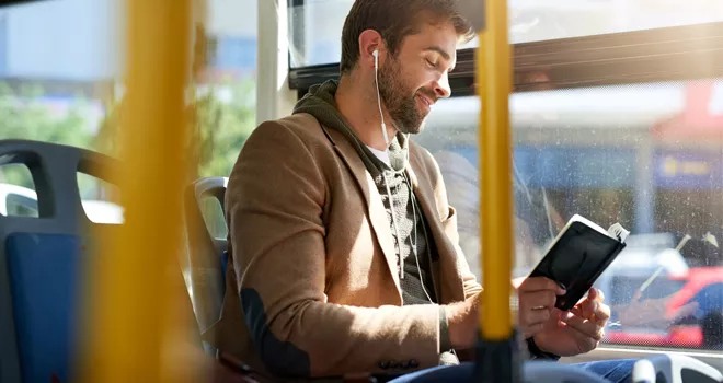 guy reading a book on a bus