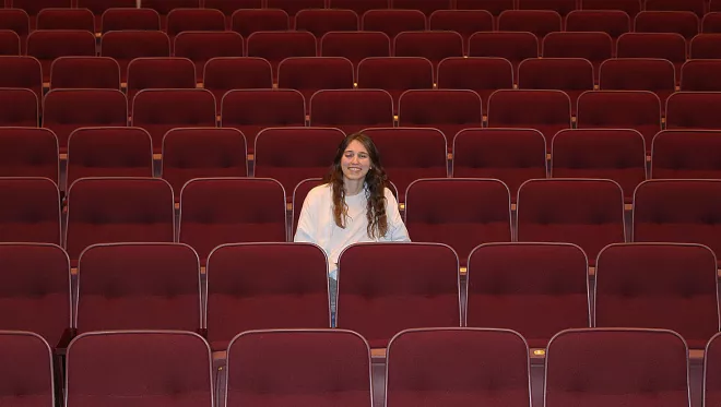 Ashley Dawson poses for a photo in an empty theatre