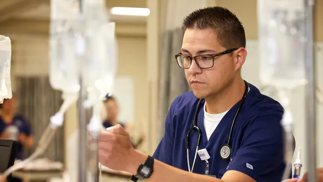 A nurse looks at an IV bag