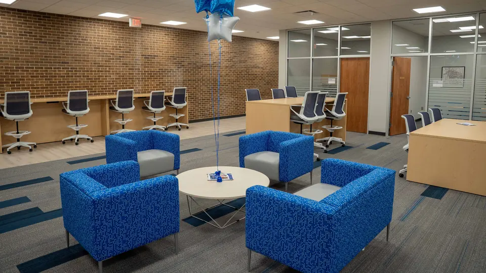 A new collaboration space in the Engineering Tech Building contains tall tables and chairs and lounge chairs.