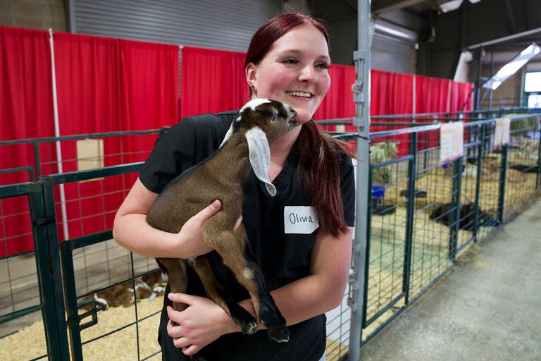 A student holds a baby goat